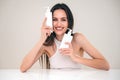 Smiling woman with perfect, clear skin holding beauty products Royalty Free Stock Photo