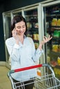 Smiling woman on phone in aisle Royalty Free Stock Photo