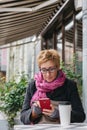 Smiling woman with phone in cafe