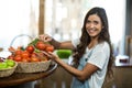 Smiling woman picking fresh tomatoes from the basket Royalty Free Stock Photo