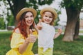 Smiling woman play on green grass lawn in park, have fun and showing thumbs up with little cute child baby girl. Mother Royalty Free Stock Photo