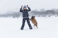 Smiling woman playing with boxer dog in winter park in snowy weather. Love, tenderness and friendship for pets Royalty Free Stock Photo