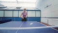 Smiling woman playing the table tennis at the court