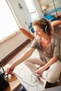 Smiling woman plugging in headphones into sound system