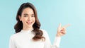 Smiling woman pointing finger side. Isolated portrait on blue Royalty Free Stock Photo