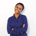 Smiling woman in polkadot shirt standing against white background