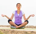Smiling woman practise yoga cross-legged