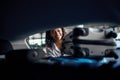 Smiling woman puts suitcases into the car, parking