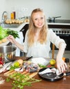 Smiling woman putting fish in flour into pan Royalty Free Stock Photo