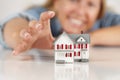 Smiling Woman Reaching for Model House on White Royalty Free Stock Photo