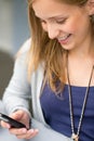 Smiling woman reading text message on cellphone Royalty Free Stock Photo