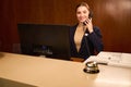 Smiling woman receptionist standing and talking on phone Royalty Free Stock Photo