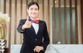 Smiling woman receptionist standing with thumps up at workplace. Portrait of Female receptionist working in hotel Royalty Free Stock Photo