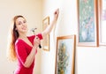 Smiling woman in red hanging art picture Royalty Free Stock Photo