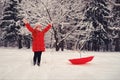 Smiling woman with a red umbrella enjoys white snow in a winter forest. A happy woman in red clothes stands in the park Royalty Free Stock Photo