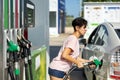 Smiling woman refueling her car in gas station Royalty Free Stock Photo