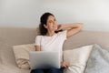 Smiling woman relax on couch in living room with laptop Royalty Free Stock Photo