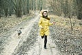 Smiling woman runs with dog in forest