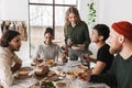 Smiling woman with salad in hand joyfully spending time with colleagues. Group of attractive international friends Royalty Free Stock Photo