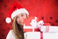 Smiling woman in santa costume holding stack of christmas gifts Royalty Free Stock Photo