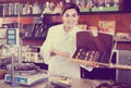 Smiling woman seller showing box of chocolate sweets Royalty Free Stock Photo