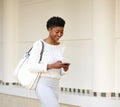 Smiling woman sending text message on mobile phone