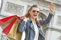 Smiling woman with shopping bags in Paris, France handwaving Royalty Free Stock Photo