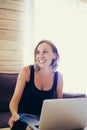 Smiling woman with short hair at table laptop