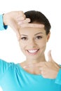 Smiling woman is showing frame by hands. Royalty Free Stock Photo