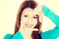 Smiling woman is showing frame by hands. Royalty Free Stock Photo