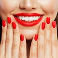 Smiling woman showing her hand with manicured nails. Red nail polish and makeup lips with bright red color tint lipstick Royalty Free Stock Photo