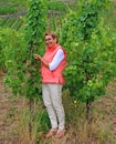 smiling woman shows ripening grapes in the vineyard Royalty Free Stock Photo