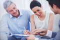 Smiling woman sign on a contrat with her partnership on sofa Royalty Free Stock Photo