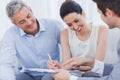 Smiling woman sign on a contrat with her partnership on sofa Royalty Free Stock Photo