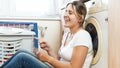 Beautiful smiling woman singing and listening music on floor at laundry room Royalty Free Stock Photo