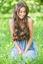 Smiling woman sits on green grass