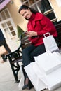 Smiling woman sitting on the bench after shopping