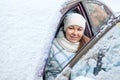 Smiling woman sitting inside of snow-covered car Royalty Free Stock Photo