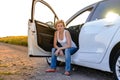 Smiling woman sitting in the open door of her car Royalty Free Stock Photo