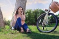 Smiling woman sitting under tree talking on the phone Royalty Free Stock Photo