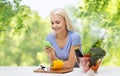 Smiling woman with smartphone cooking vegetables