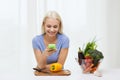 Smiling woman with smartphone cooking vegetables