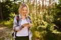 Smiling woman with smartphone during summer hike