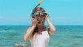 Smiling woman in snorkel mask enjoying ocean view, standing in sea water.