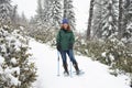 Smiling woman snow shoer trekking in forest Royalty Free Stock Photo