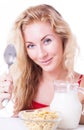 Smiling woman with spoon, milk and corn-falkes