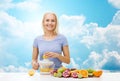 Smiling woman squeezing fruit juice over sky Royalty Free Stock Photo