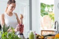 Smiling woman squeezing orange juice