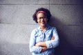 Smiling woman standing with her arms crossed against a wall Royalty Free Stock Photo