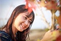 Smiling women standing outdoors and looking maple leaves at summer day